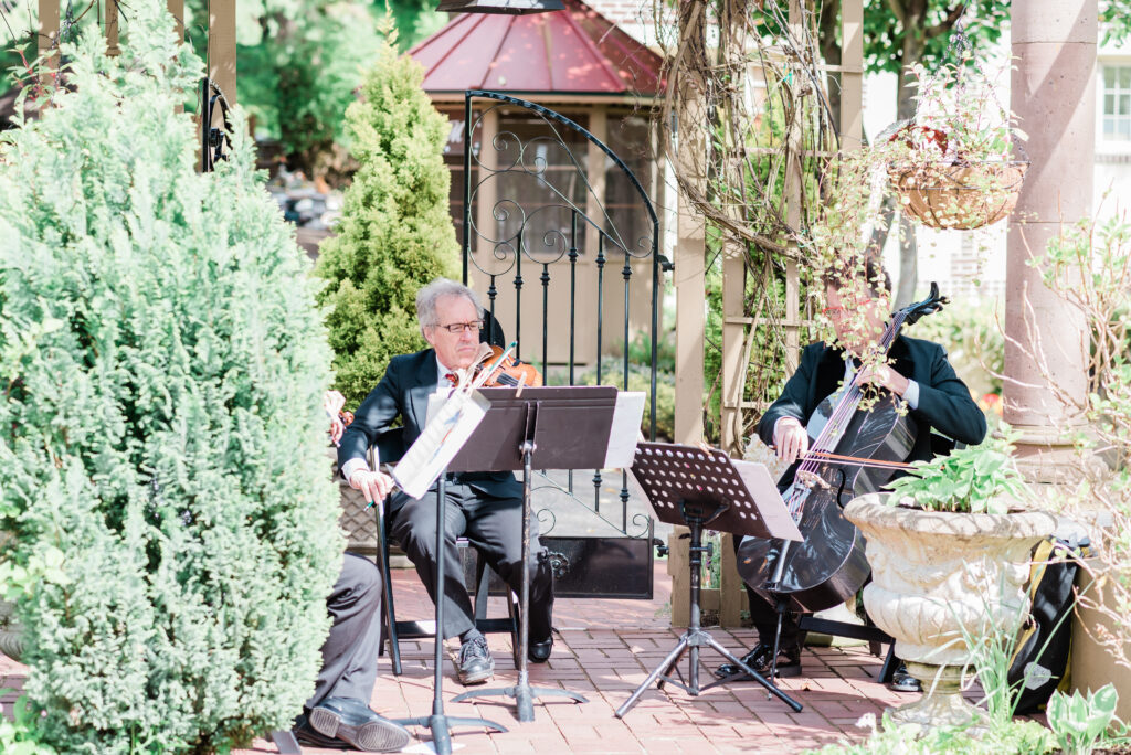 A string trio playing classical music as guests arrive before the wedding ceremony at historic Lairmont Manor