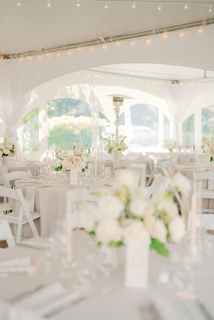 Elegant wedding reception inside a white tent with floral centerpieces at Lairmont Manor, a beautiful garden wedding venue in Washington.