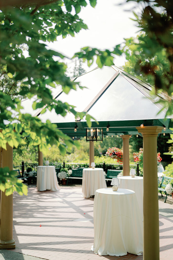 Outdoor terrace cocktail hour setup with cocktail tables at Lairmont Manor, a charming garden wedding venue in Washington.