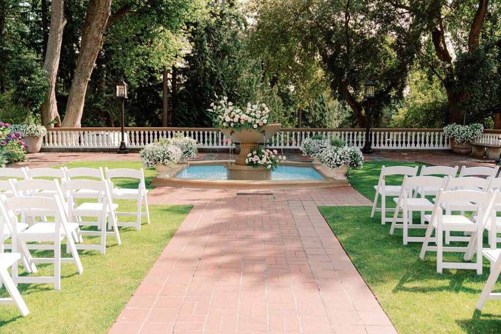 Brick garden pathway leading to iconic Lairmont ceremony fountain surrounded by flowers at Lairmont Manor, a classic Pacific Northwest garden wedding venue.