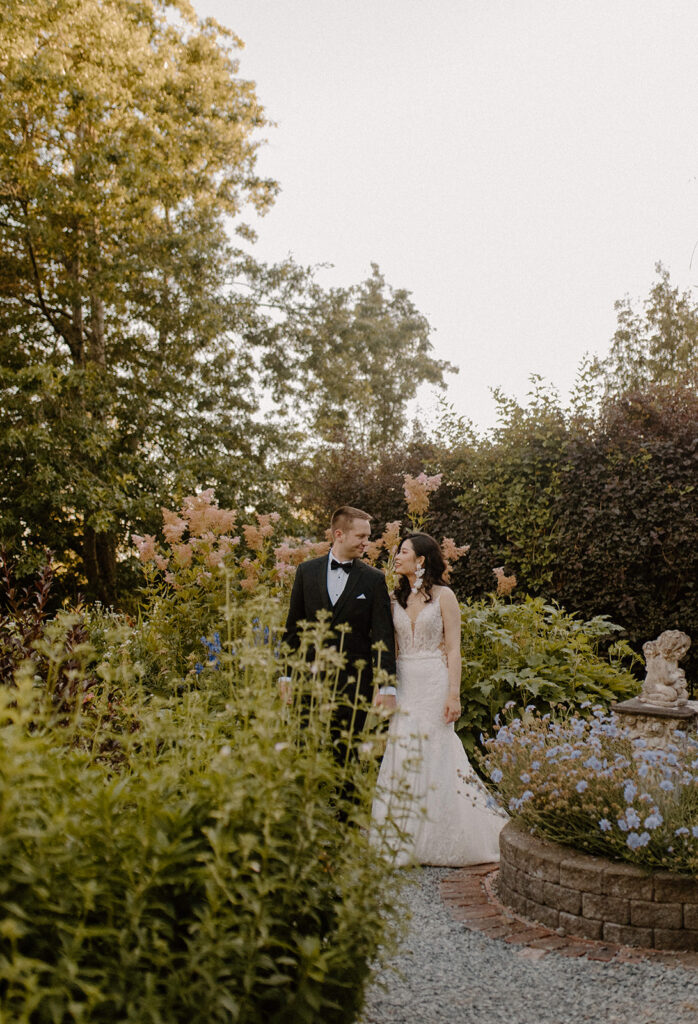 Garden wedding couple portrait walking through lush flowers at Twin Willow Gardens, one of the most romantic garden wedding venues in Washington.