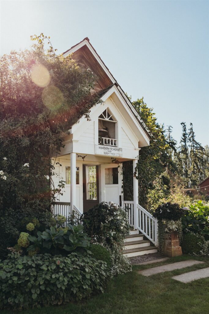 Entrance to Christianson's Nursery Schoolhouse surrounded by lush greenery, a charming example of garden wedding venues in Washington.