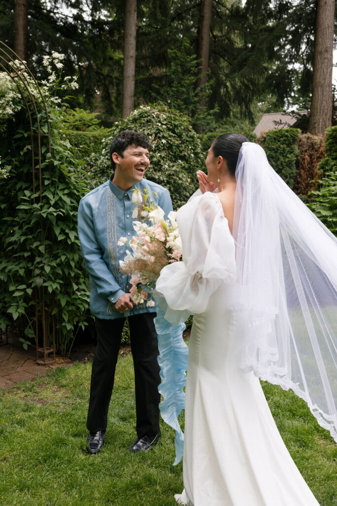 Bride and groom sharing a joyful moment during First Look in the gardens at Evergreen Gardens, a beautiful Washington garden wedding venue.