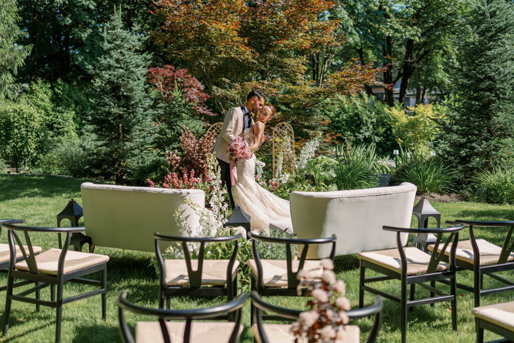 Bride and groom embracing in a lush garden ceremony setting at Parties on the Terrace, a beautiful example of garden wedding venues in Washington.